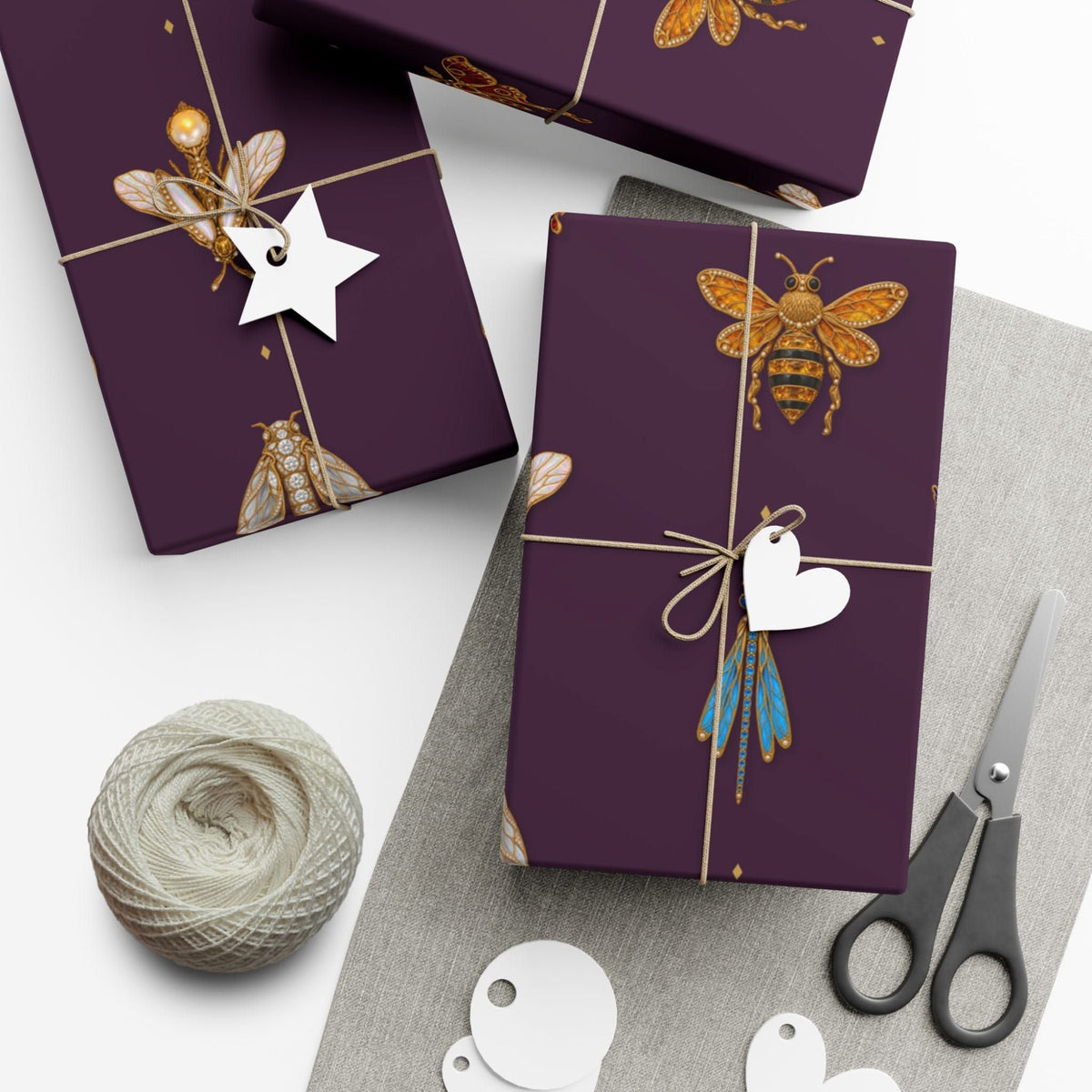 Gifts wrapped in deep plum jeweled insect wrapping paper with twine and tags