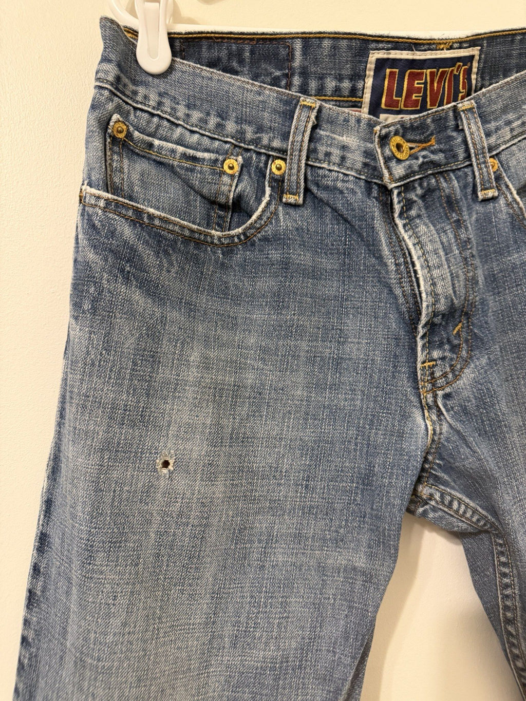 Small distressed hole on front thigh