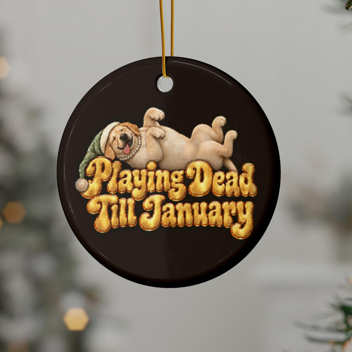 Playing Dead Till January yellow lab ornament hanging on a Christmas tree