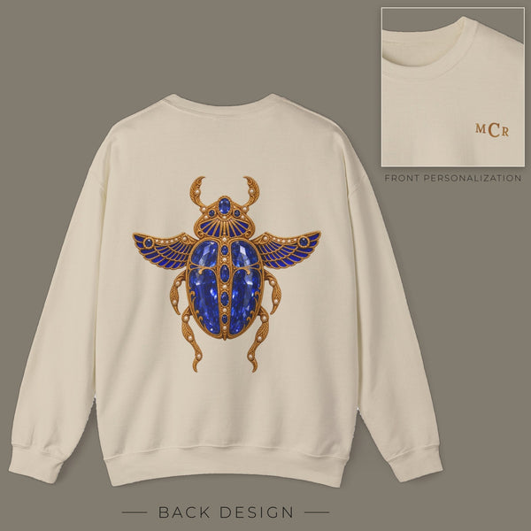Back of sand sweatshirt with jeweled sapphire scarab brooch design; inset shows the front with personalized monogram on the left chest