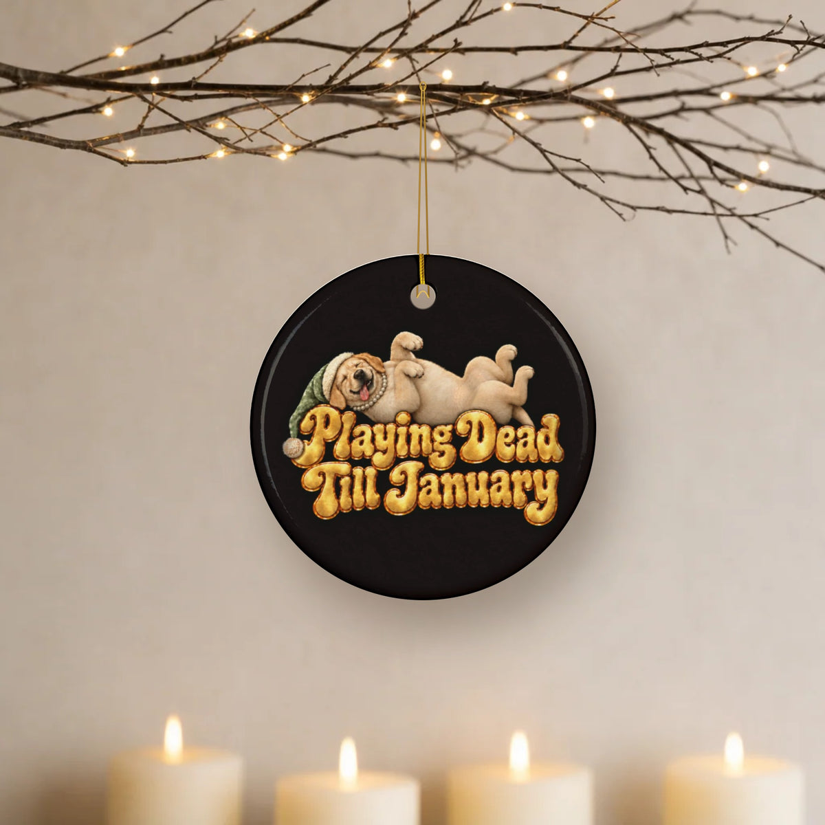 Playing Dead Till January yellow Lab ceramic Christmas ornament hanging from lit twigs with candles